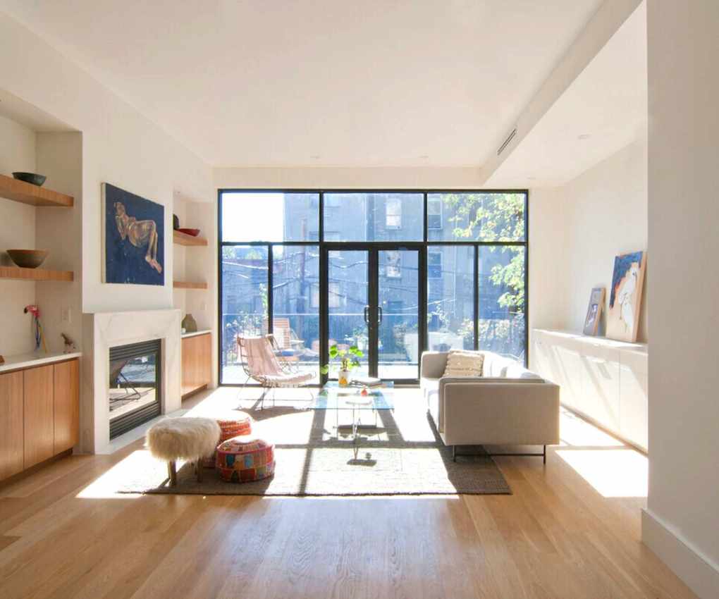 Neutral living room with floor to ceiling window and door leading to balcony